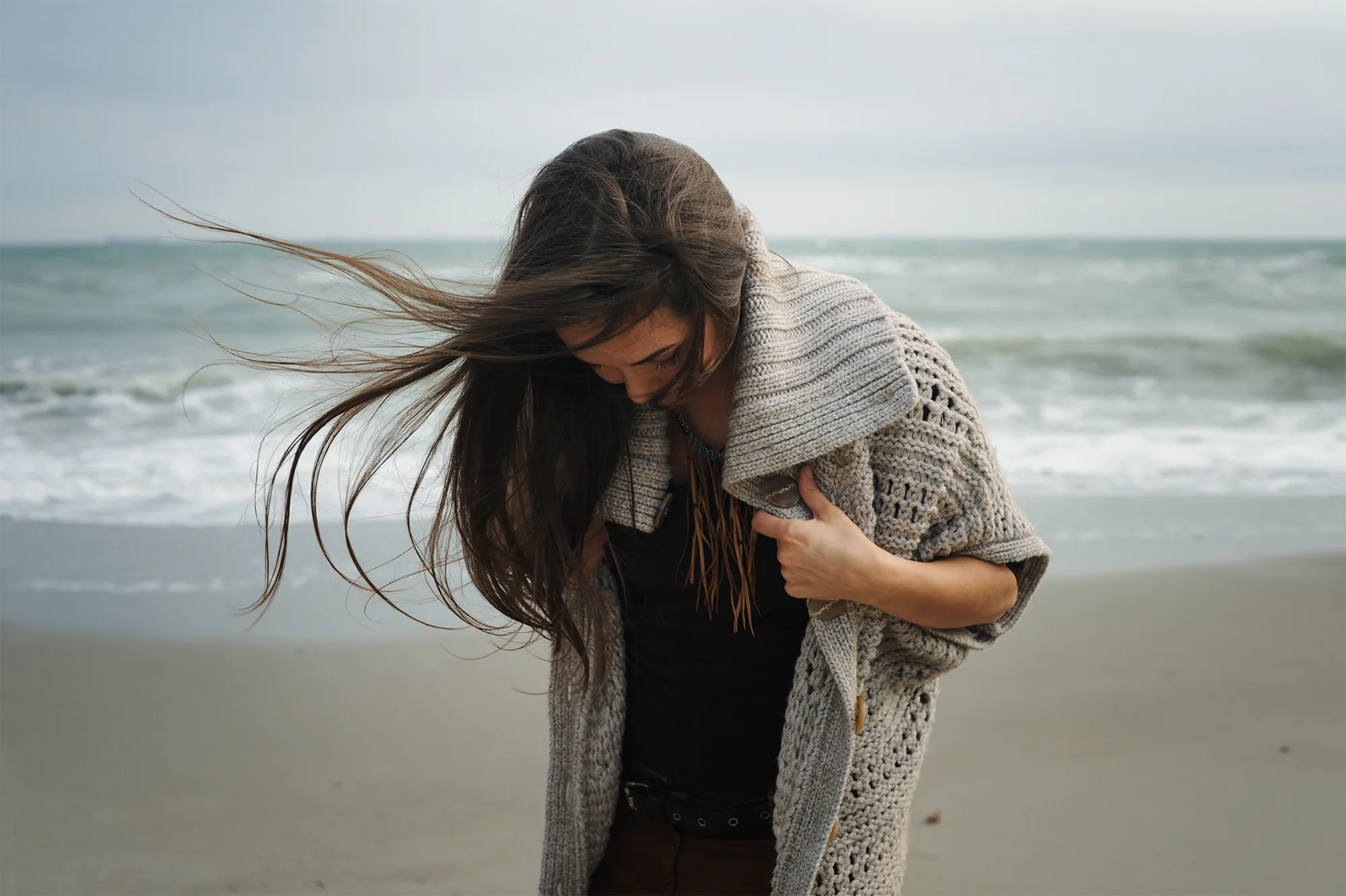 woman looking down on beach